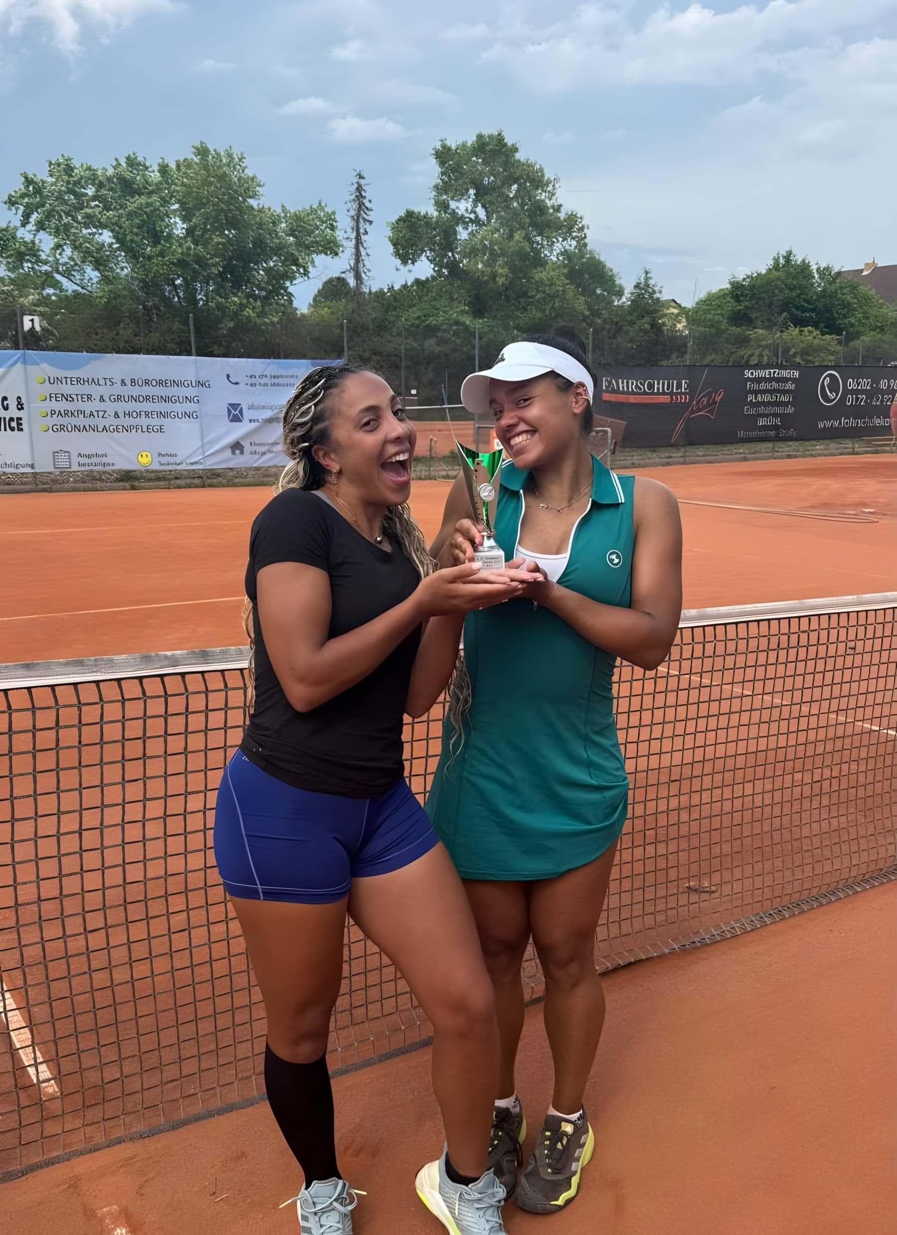 Sophia et Jade, hilares, un trophée entre les mains au bord du filet